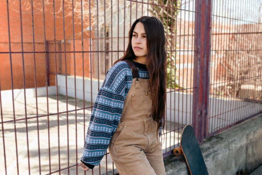 Teen girl in casual outfit, skateboard.